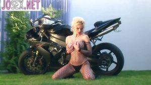 Грудастая блондинка ласкает себя на мотоцикле в нейлоне